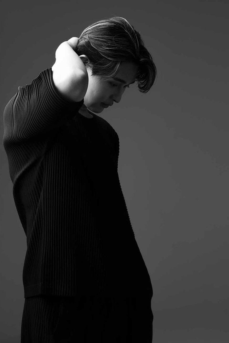 首に手をやり、うつむく黒い服の男性