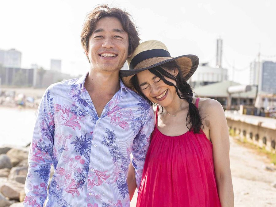 海辺で寄り添って笑う男女