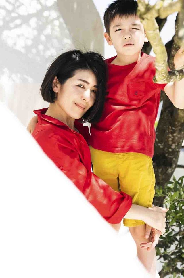 木にもたれて寄り添う、赤い服の親子