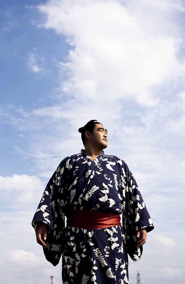 青空の下、藍の浴衣で立つ力士