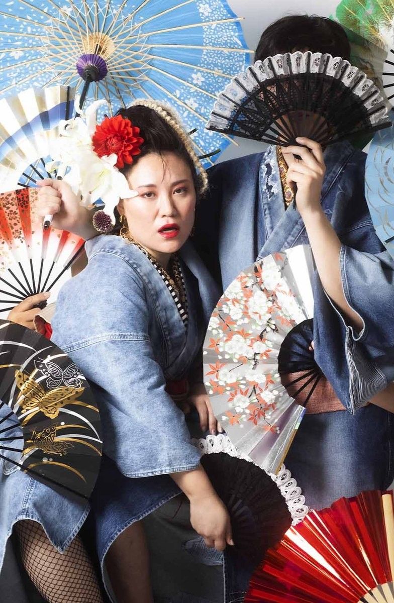 和傘と扇を手に、デニムをまとった二人の女性
