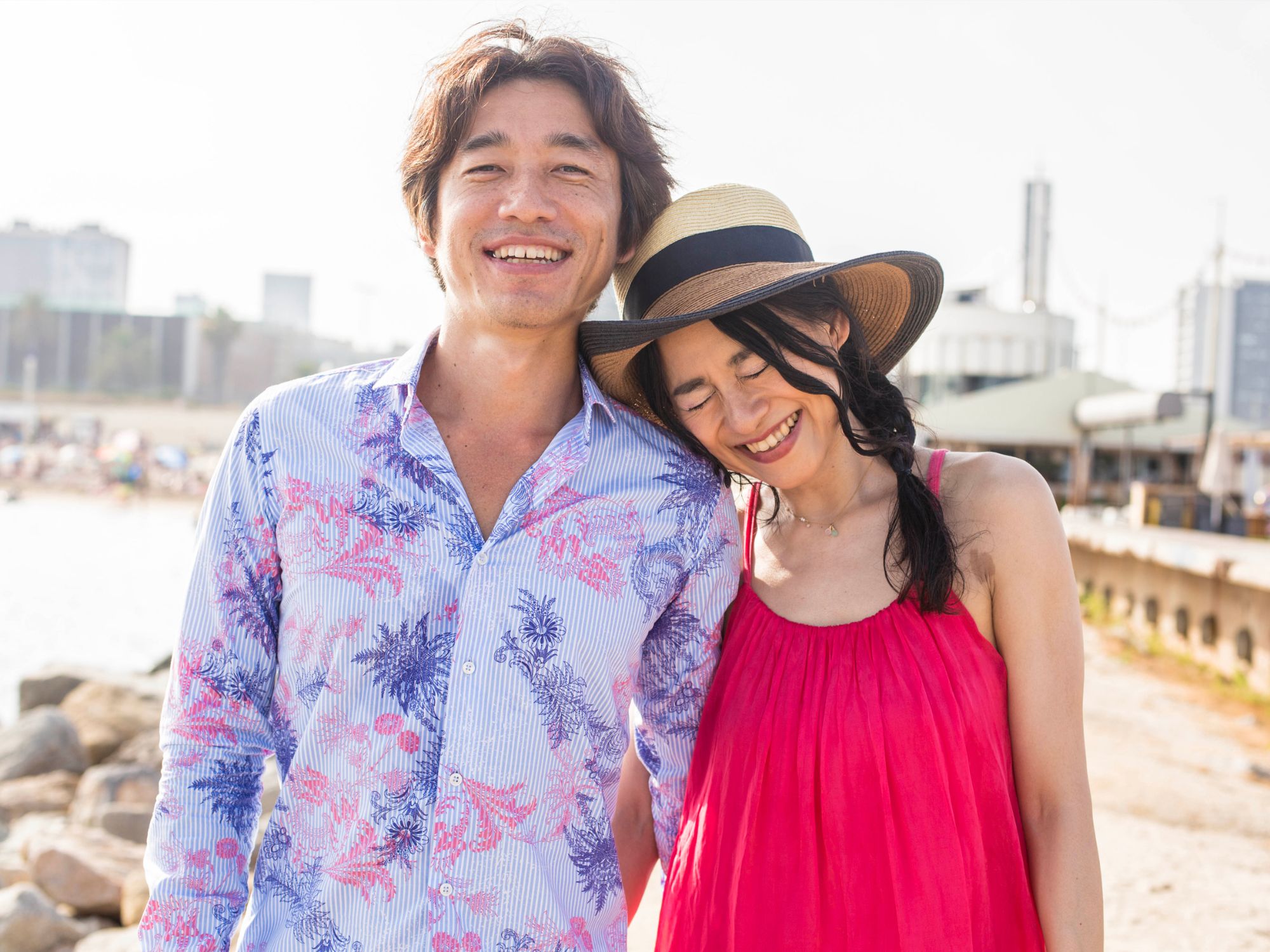 海辺で寄り添い、笑い合う男女